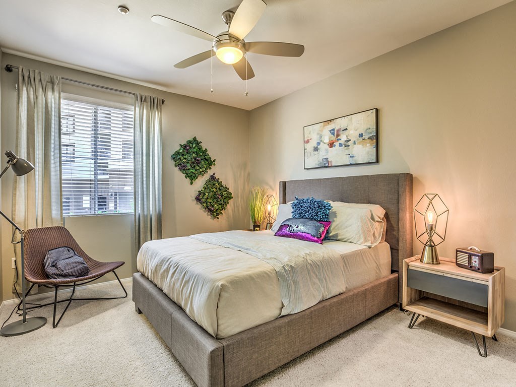 a bedroom with a bed and a ceiling fan