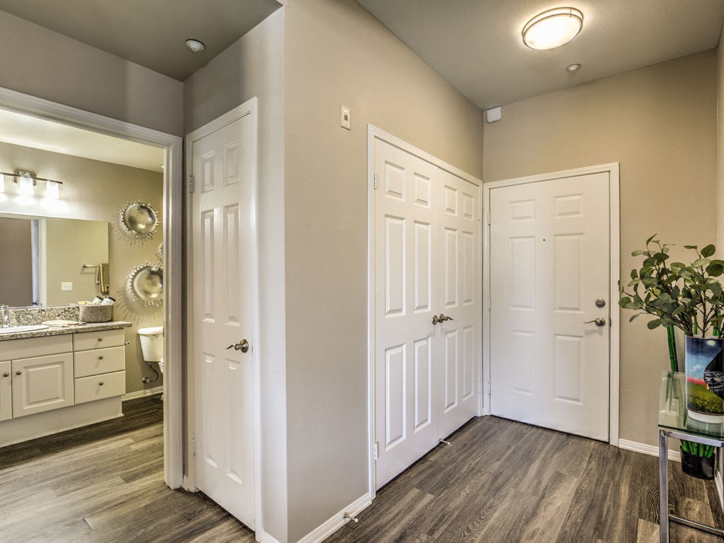 an empty room with three doors and a sink and a mirror