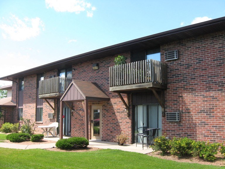 a brick building with two balconies and a porch