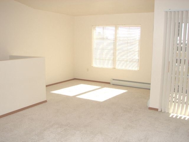 an empty room with a window and a radiator