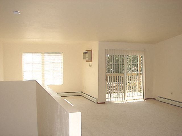 an empty living room with a door and a window