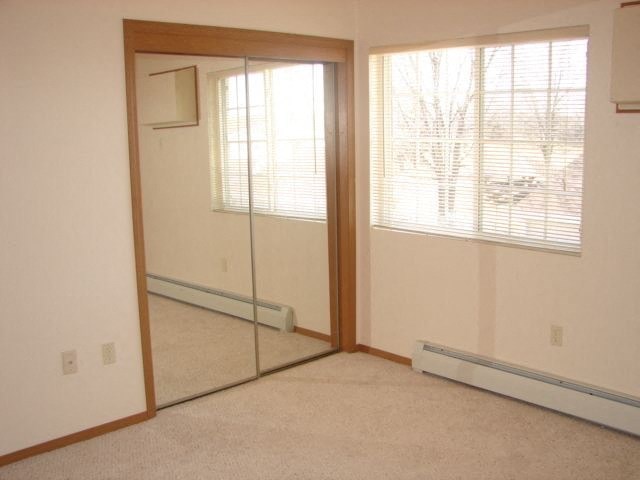 an empty room with a mirror and a window