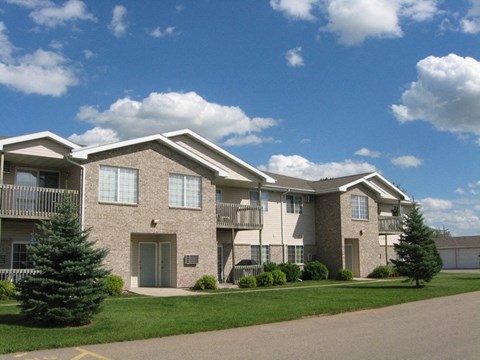 an apartment building with green grass and trees