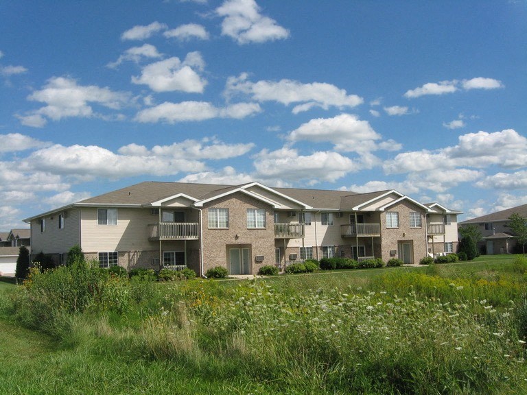 an apartment building on a sunny day in a field