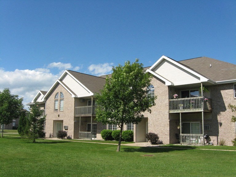 an apartment building with green grass and trees