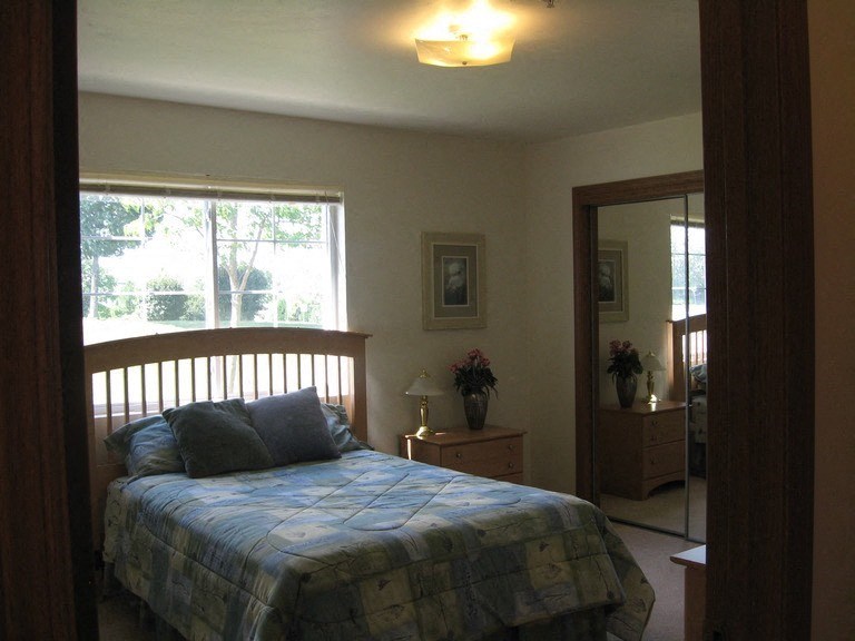 a bedroom with a bed and a mirror