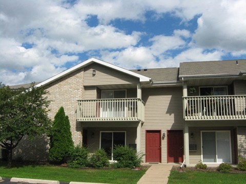 an apartment building with a red door and a balcony