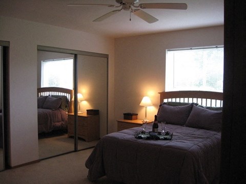 a bedroom with a bed and a ceiling fan