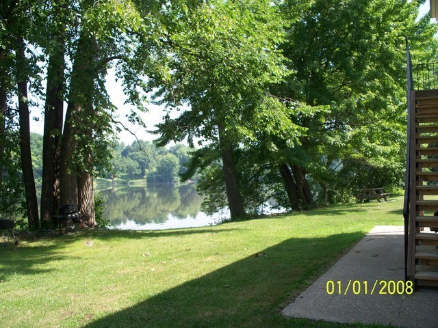 a view of a lake from a park with trees