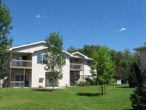 a white apartment building with trees in front of it