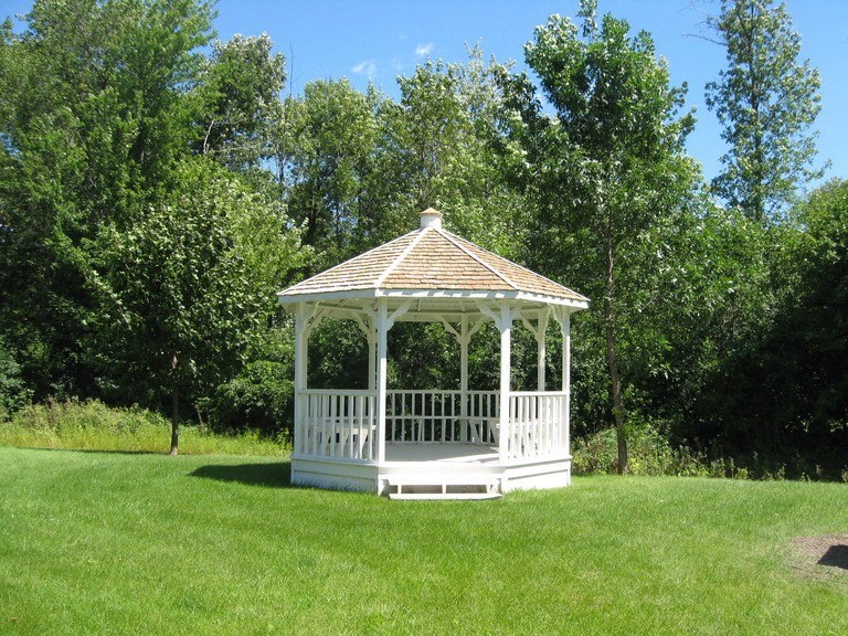 a white gazebo in the middle of a field
