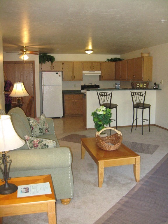 a living room and kitchen with a couch and a table