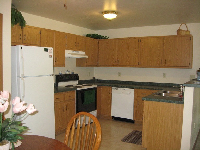 a kitchen with white appliances and wooden cabinets
