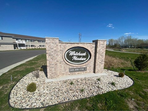 a sign in front of a building on the side of a road