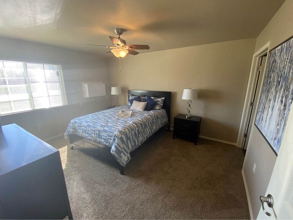 a bedroom with a bed and a ceiling fan