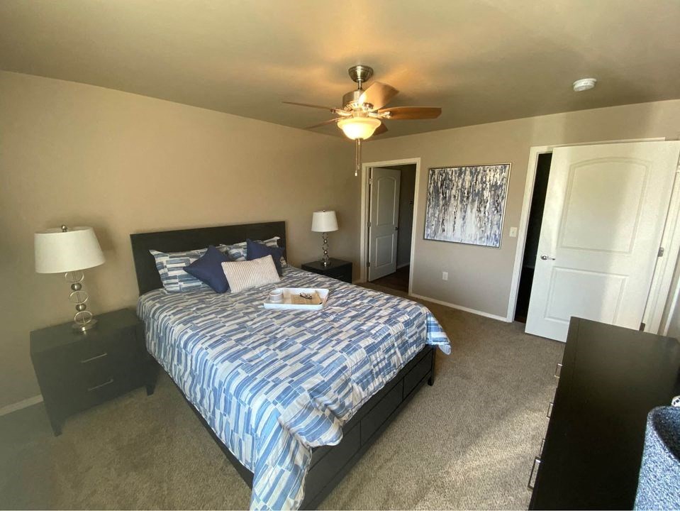 a bedroom with a bed and a ceiling fan