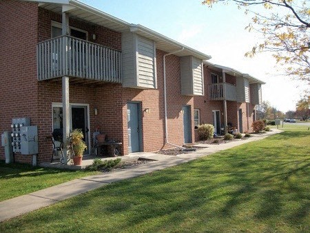 a brick apartment building with a balcony and a sidewalk