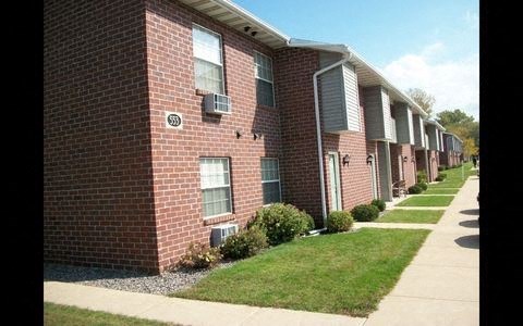 a row of brick apartment buildings next to a sidewalk