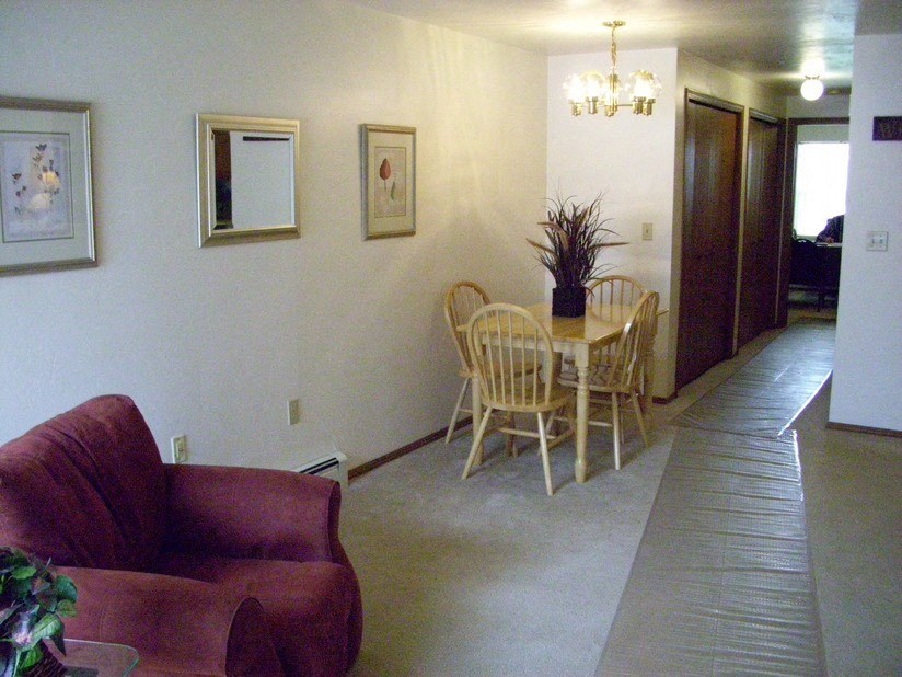 a living room and dining room with a table and chairs