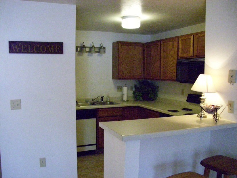 an empty kitchen with a welcome sign on the wall