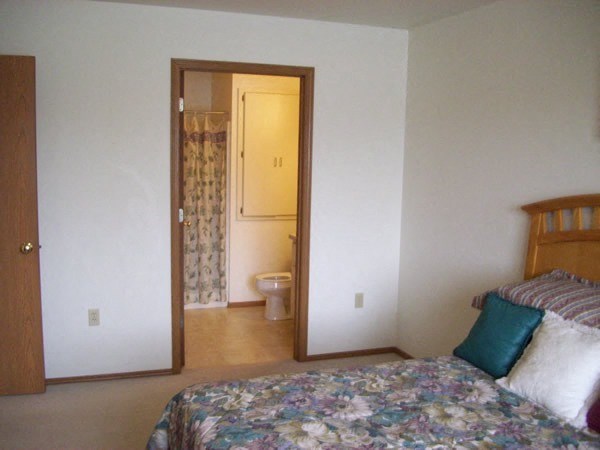 a bedroom with a bed and a bathroom with a toilet