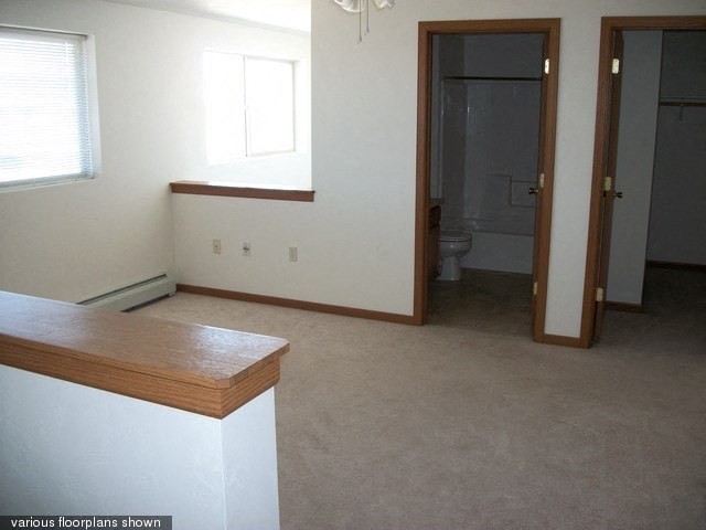 an empty room with a kitchen and a bathroom