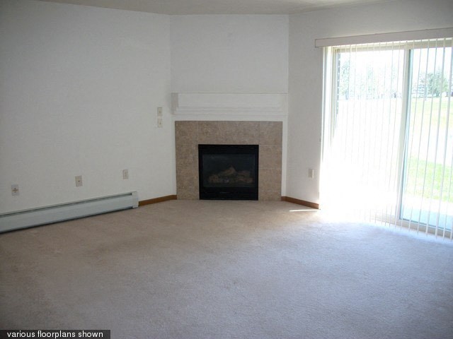 an empty living room with a fireplace and a window