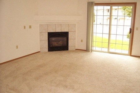 an empty living room with a fireplace and a window