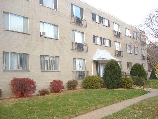 a brick apartment building with a sidewalk in front of it