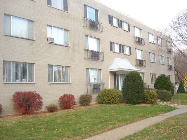 a brick apartment building with a sidewalk in front of it