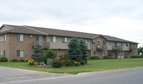 Apartment building with a green bush in front.