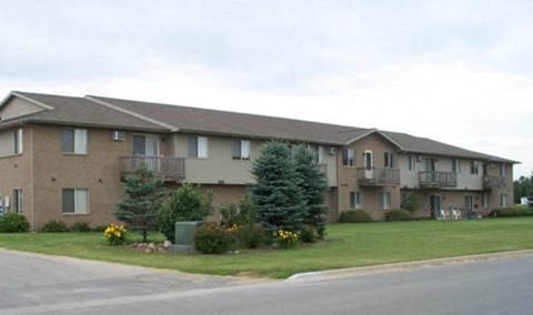 Apartment building with a green bush in front.