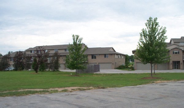 Apartment complex with a parking lot in front.
