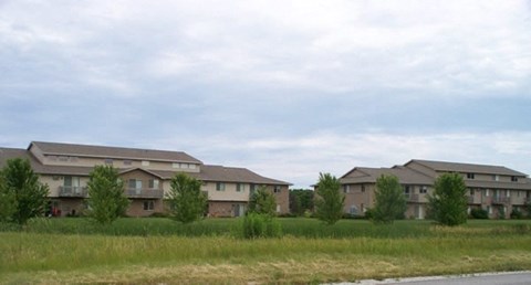 A row of houses with grass in front.