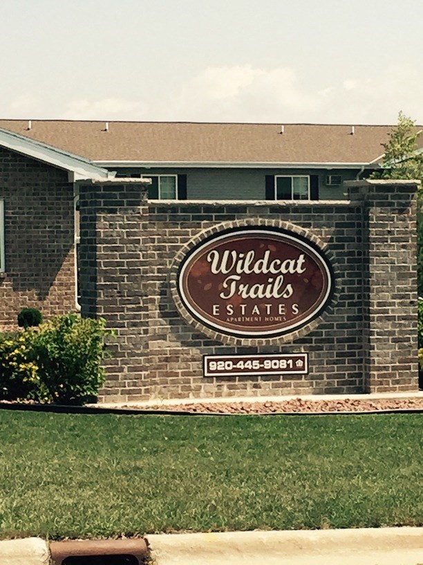 a sign on a brick wall in front of a building