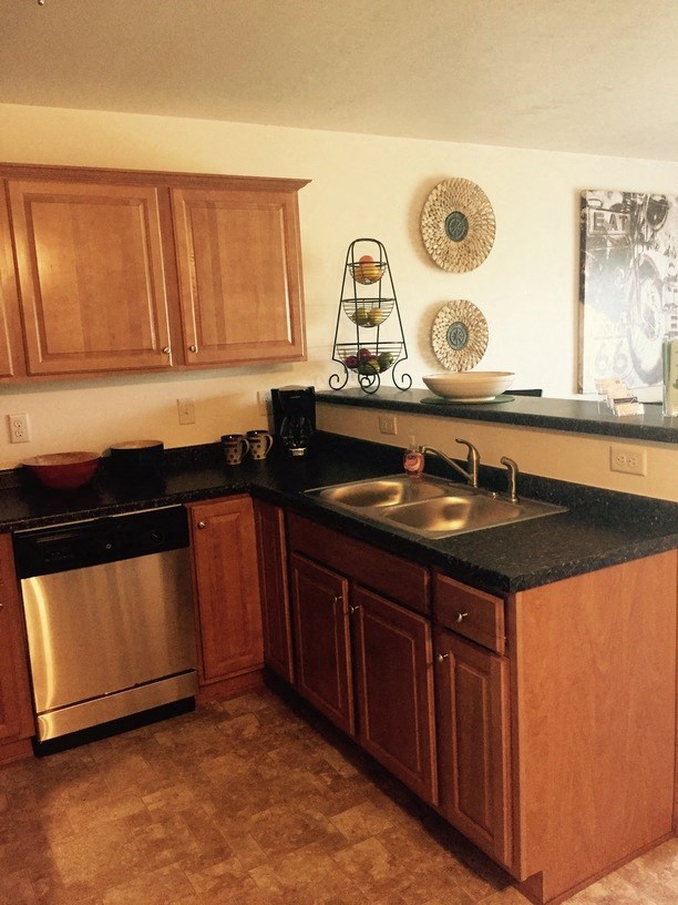 a kitchen with wooden cabinets and a stainless steel sink