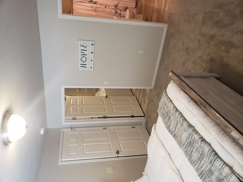 A white cabinet with a mirror on top of it.