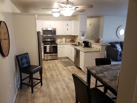 A kitchen with a black chair and a table.