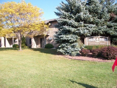 a lawn in front of a building with a sign