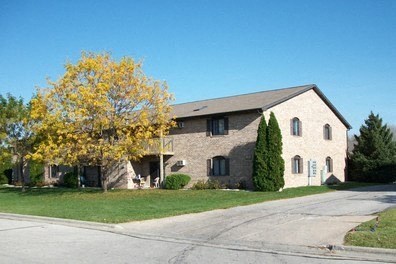 a brick house with a tree in front of it