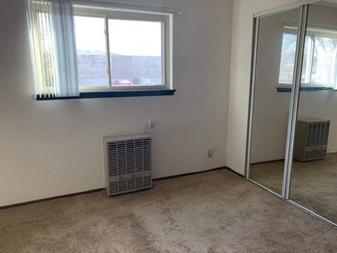 a room with a radiator and a window and a mirror