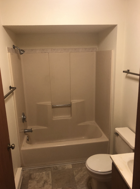 A white toilet sits in a bathroom next to a walk-in shower.