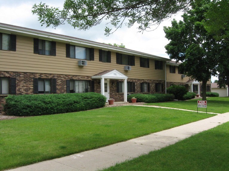 a building with a lawn and a sidewalk in front of it