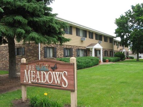 the meadows resort and spa sign in front of a building