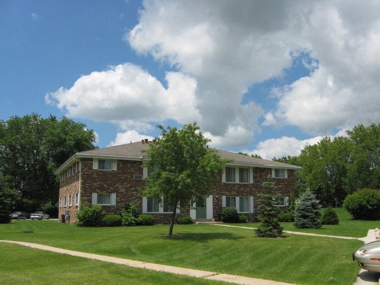 a house with a lawn and a tree in front of it