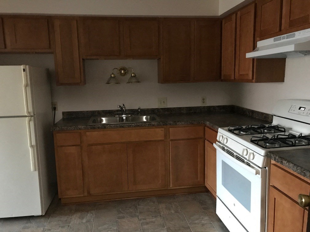 an empty kitchen with a stove and a sink