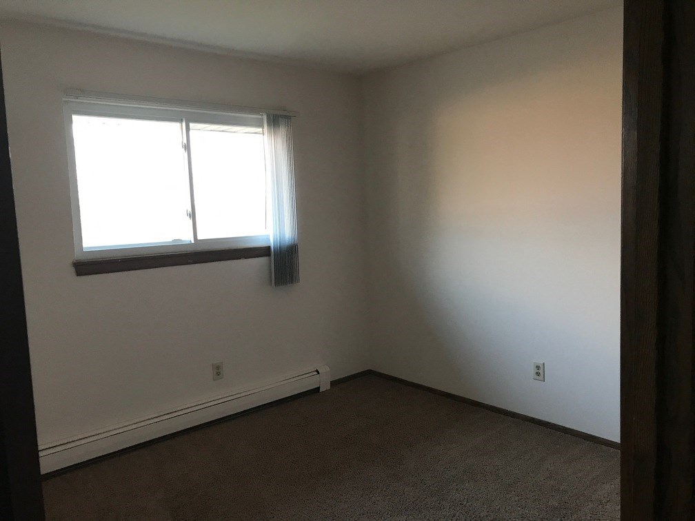 a small room with a window and a carpet