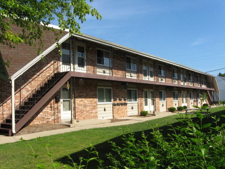 a brick apartment building with stairs and a balcony
