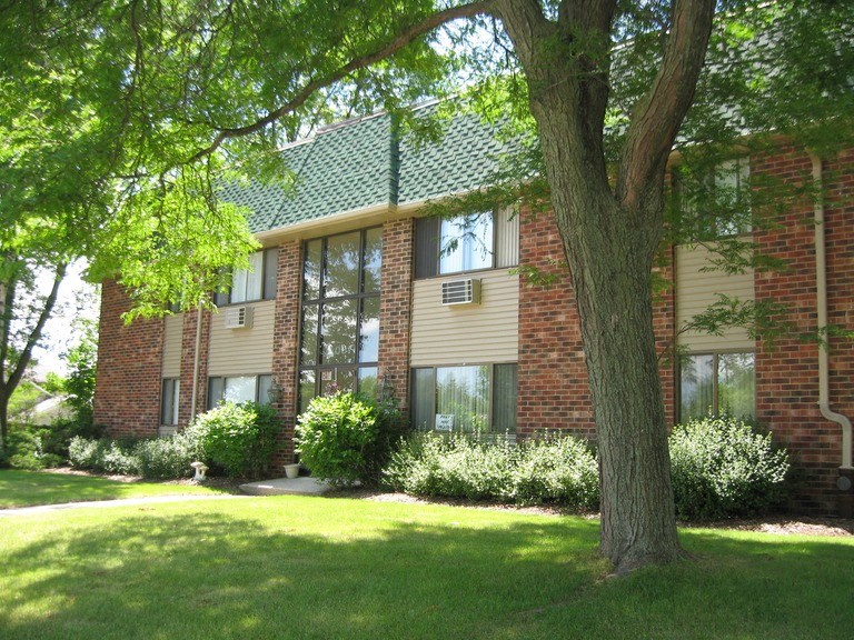 a large brick building with a tree in front of it