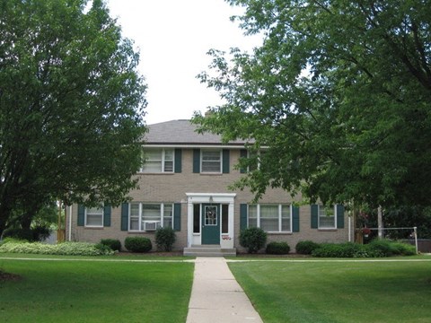 a brick house with a lawn in front of it